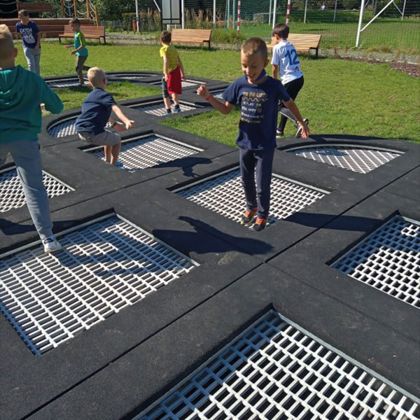 Firkantet trampolin sammensat hvor børn hopper.