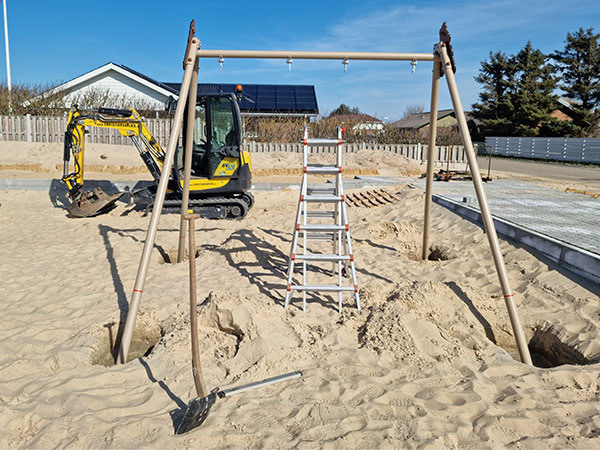 Gyngestativ er ved at bliver monteret på havnens legeplads.