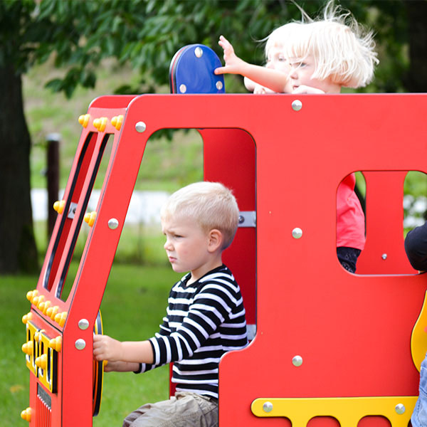 Børn leger i i brandbilen, som er en af legehusene i institutionen .