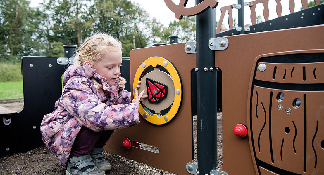 Pige leger med kompas som understøtter barnet med læring gennem leg.