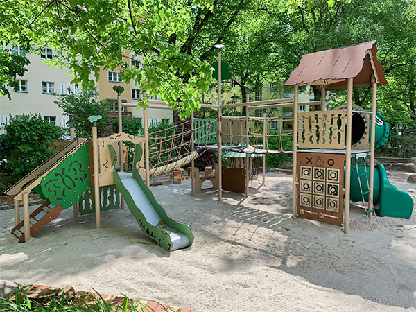 Stort legesystem med 3 legetårne og hængebro imellem legetårnene.