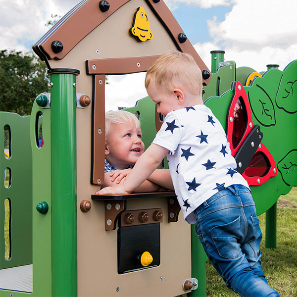 Børn øver rolleleg ved en kiosk, som er en del af et legesystem.