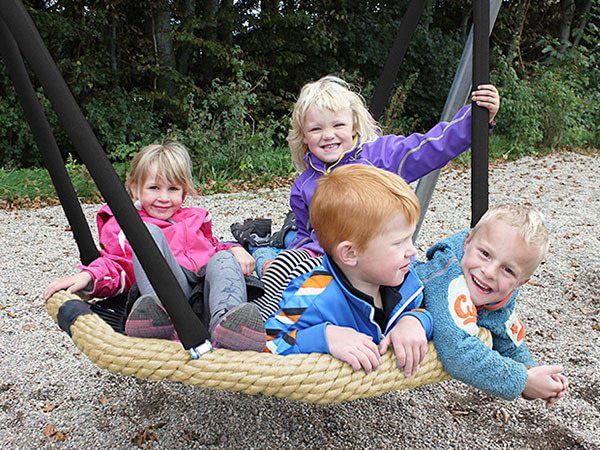 I fuglerede gyngen på den offentlige legeplads tager de små børn en slapper.