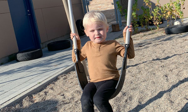 Barnet får en sjov gyngetur på legepladsen på bæverhalegyngesædet.