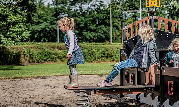 Pige leger på planke som giver barnet meget læring gennem leg og bevægelser.