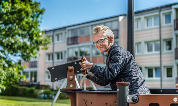 Dreng leger med kikkert på skib, som er populær på legepladser til skoler.