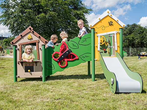 Børn leger på legeredskaber på offentlig legeplads.