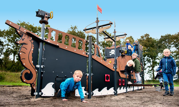 Børn leger på et stort pirat legeskib, som er vedligeholdselsefrit.