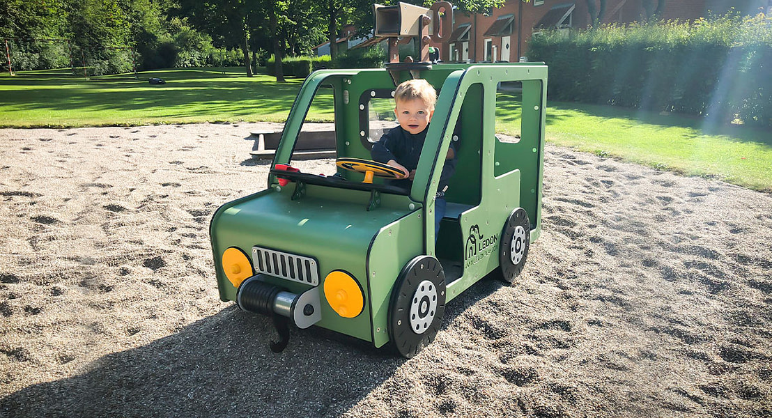Drenge leger i legehus i institution, designet som en grøn bil.