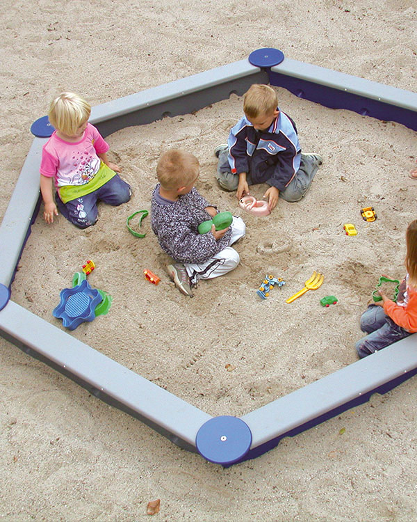 Nedgravet sandkasse hvor børn leger.