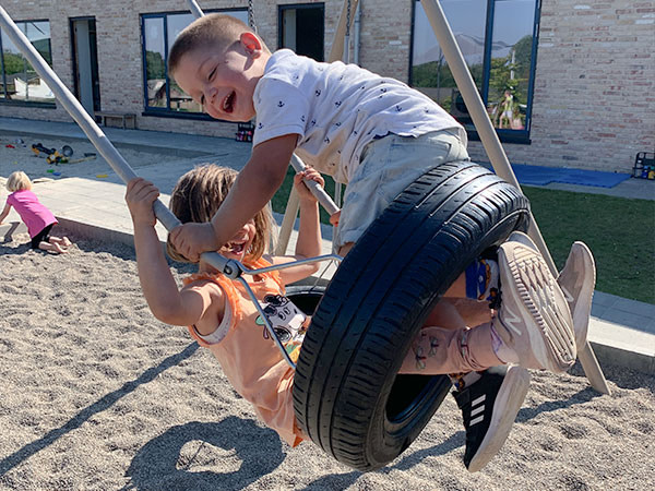 Børnene gynger højt på dækgyngen fra Ledon.