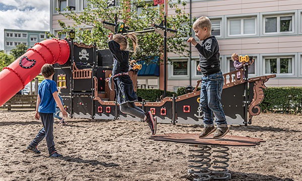 Børn leger på godkendt legeplads fra dansk legepladsleverandør.