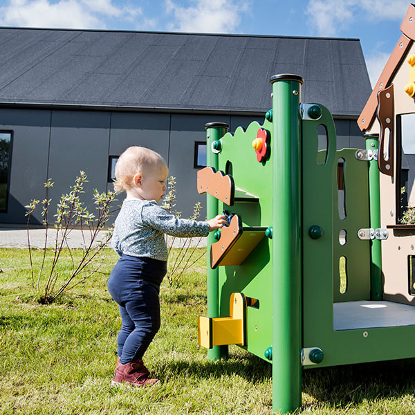 Pige leger ved legestation på legeplads for de mindste børn 0-3 år.